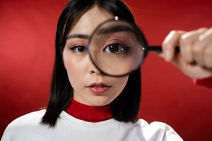 Woman peering through a magnifying glass