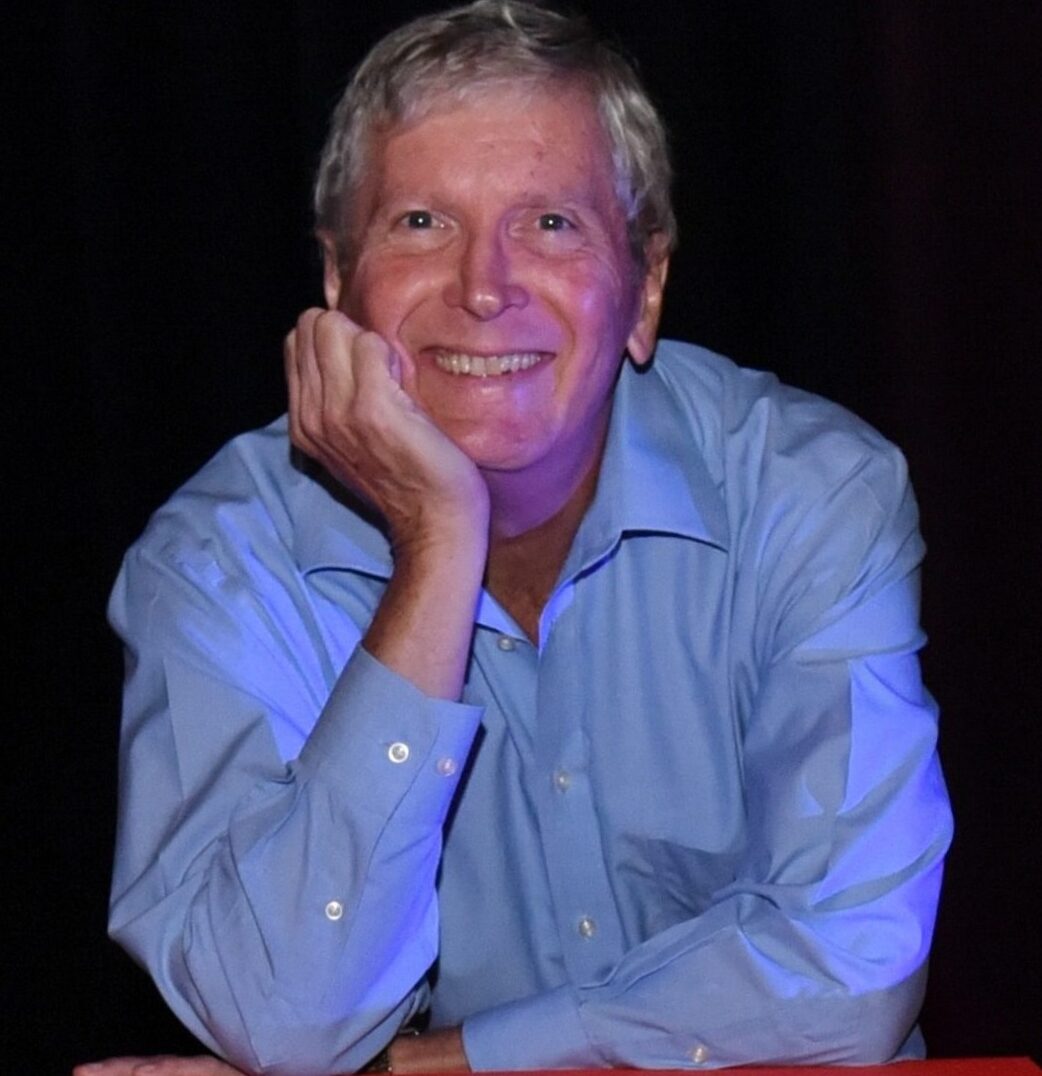 Jim Barber leaning on TEDx logo